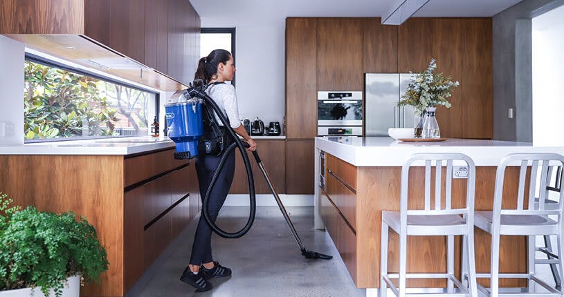 lady vacuuming in kitchen
